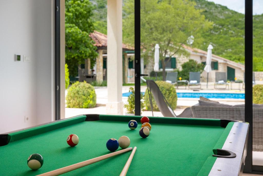 a pool table with balls on it in a house at Villa Silentio Luxury with pool, jacuzzi & sauna in Podgora