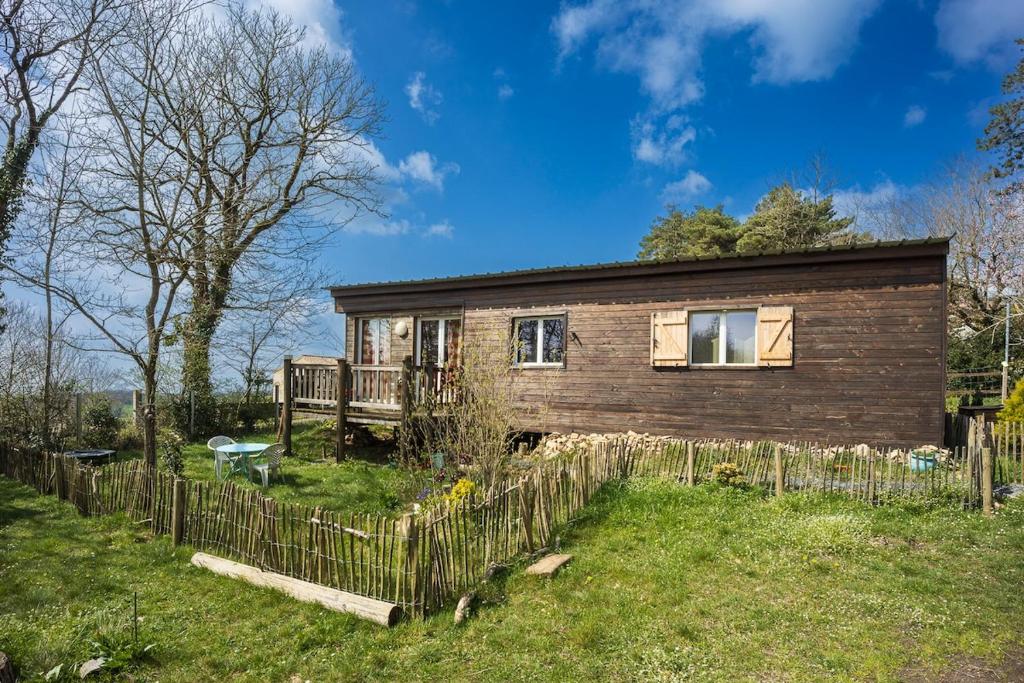 a wooden house with a fence in front of it at Container Maritime Montagne Noire in Fontiers-Cabardès