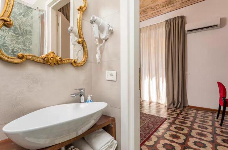 a bathroom with a white sink and a mirror at DS Apartment in Catania