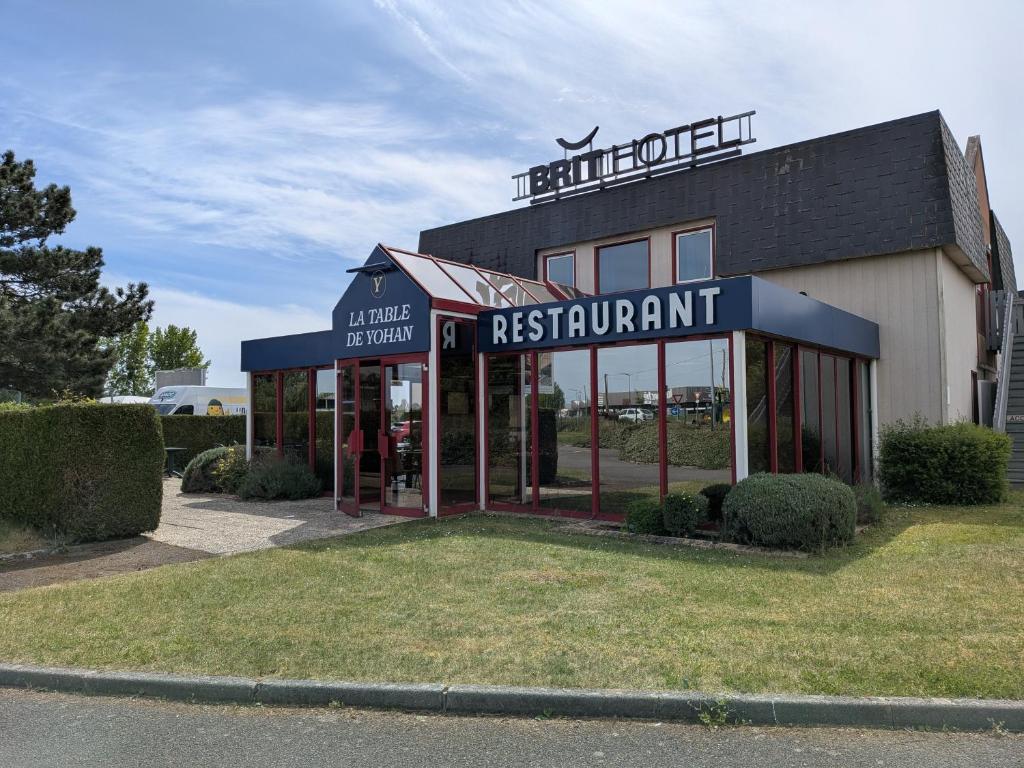 a restaurant building with a sign on top of it at Brit Hotel Argentan in Argentan