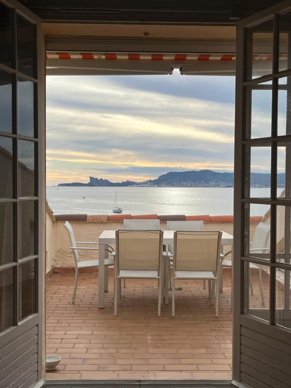 a table and chairs on a balcony with a view of the ocean at Azurea in Saint-Cyr-sur-Mer