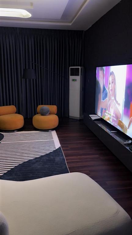 a bedroom with a bed and a flat screen tv at Alexa Smart Home One Bedroom Luxury Apartment in Lekki