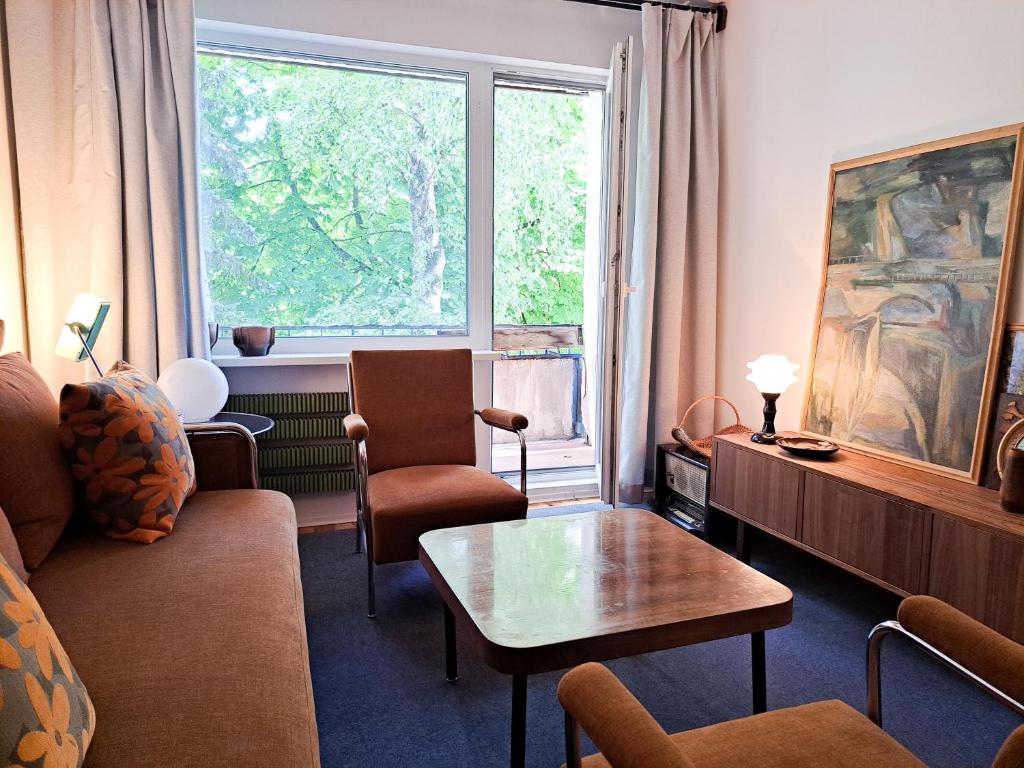 a living room with a couch and a table and a window at Cozy Vintage Apartment in Klaipėda
