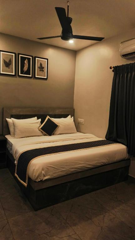 a bedroom with a large bed with a ceiling fan at KRS PARADISE premium suite room in Tiruvannāmalai