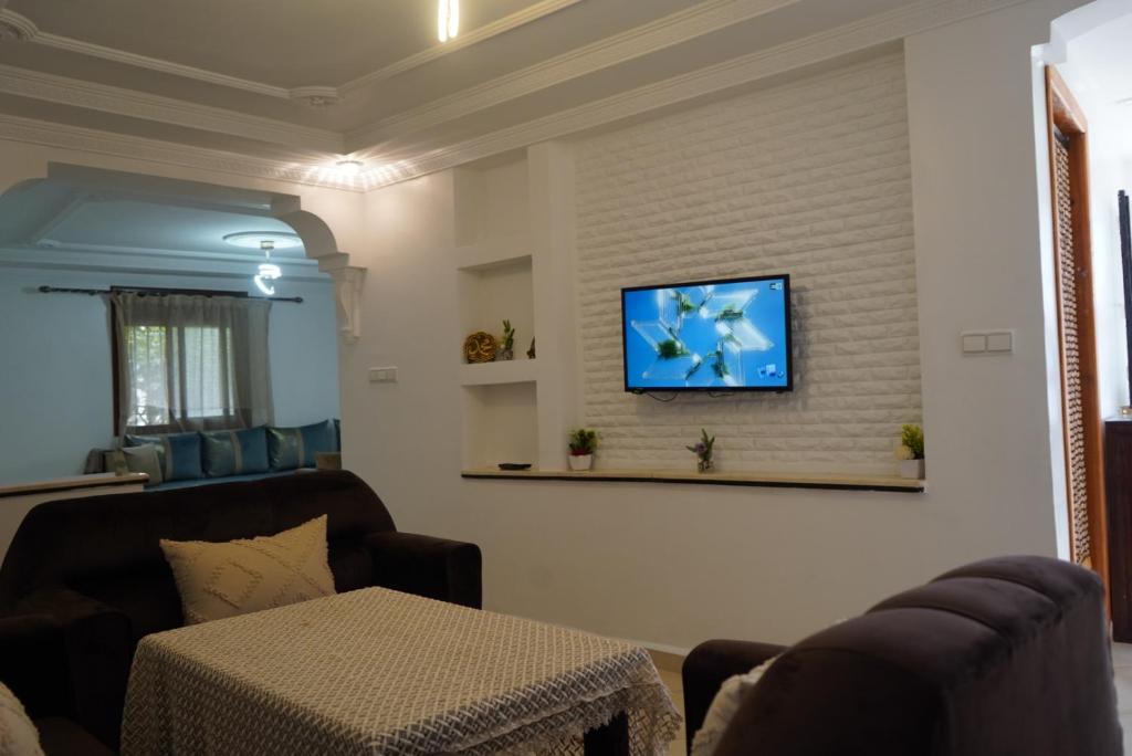 a living room with a couch and a tv on a wall at Studio MLK in Chefchaouen
