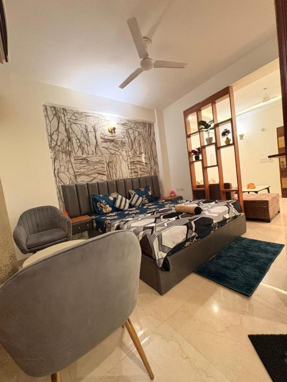 a bedroom with a bed and a couch and a chair at Hare Krishna Orchid Society in Vrindāvan