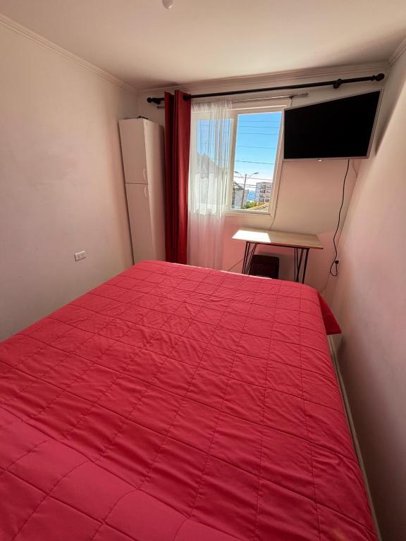 a red bed in a room with a window at Barros Borgoño 2 Departamento in Valparaíso