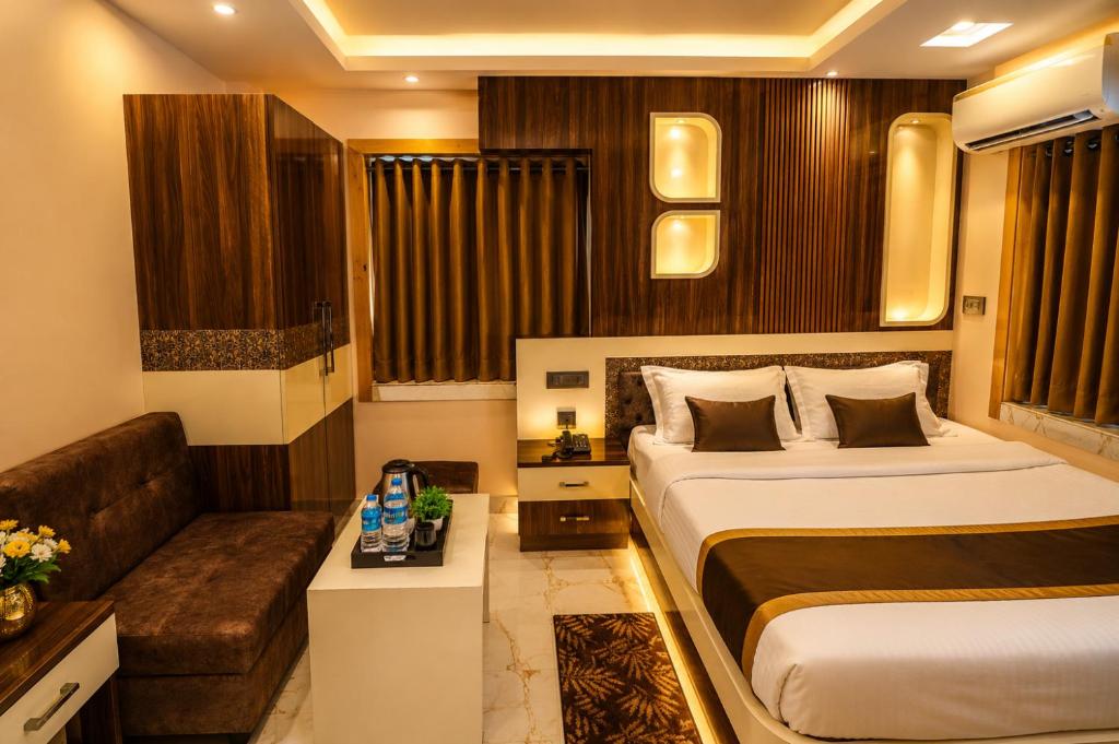 a hotel room with a bed and a couch at Mohar Residency - VIP Road in kolkata