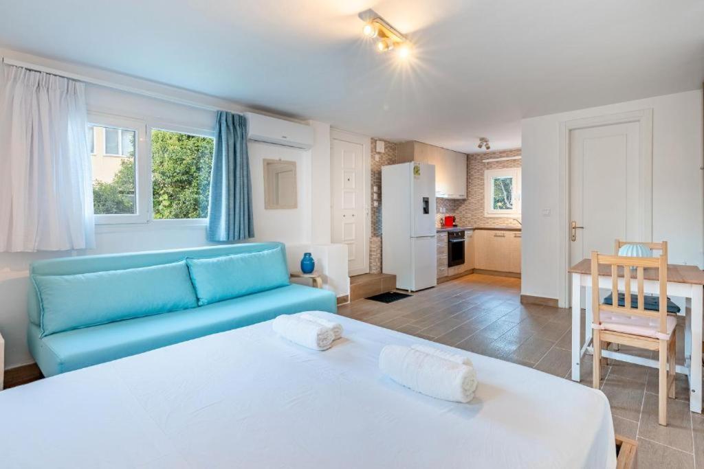 a large bedroom with a blue couch and a kitchen at Santa Decca in Áyioi Dhéka