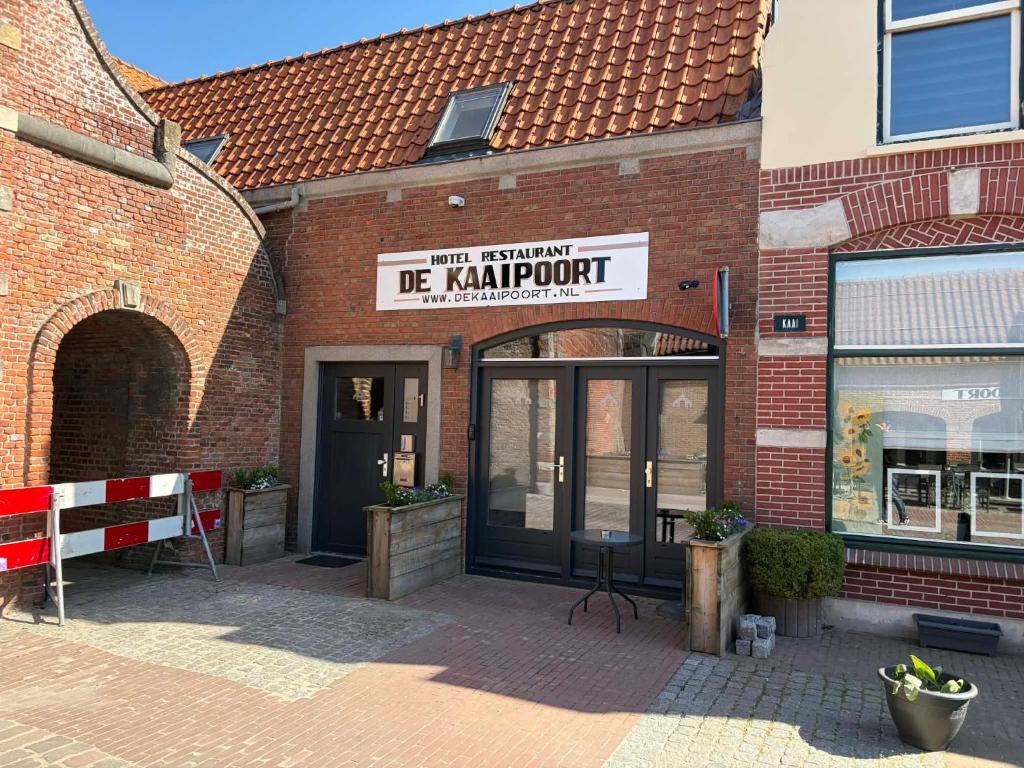 a brick building with a sign that reads be karmatown at hotel de kaaipoort in Aardenburg