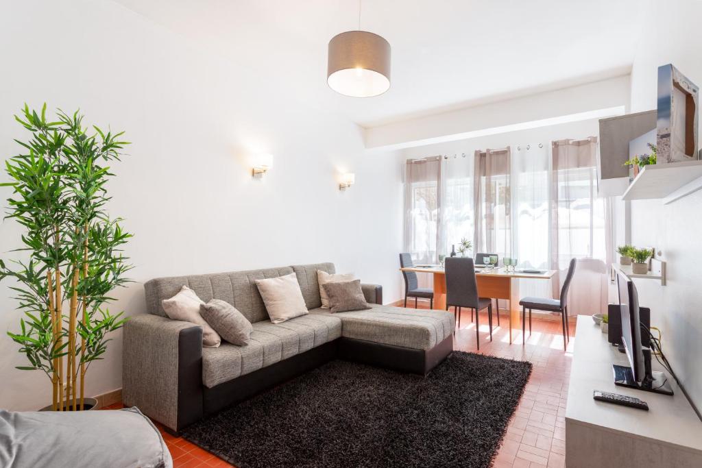 a living room with a couch and a table at Refúgio do Mar -Steps from the Beach- in Armação de Pêra