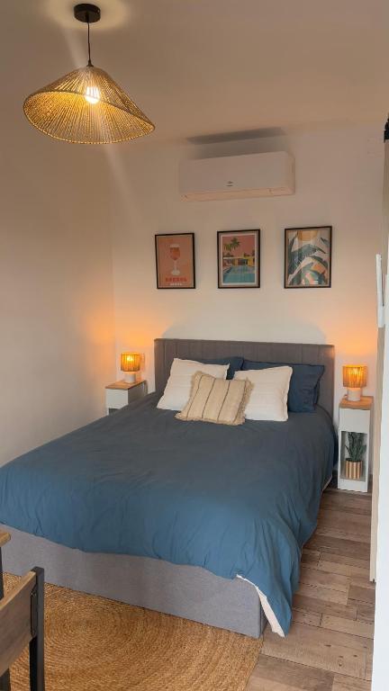 a bedroom with a large blue bed with two lamps at Escapade paisible Studio design à Saint-Mesmin in Saint-Mesmin
