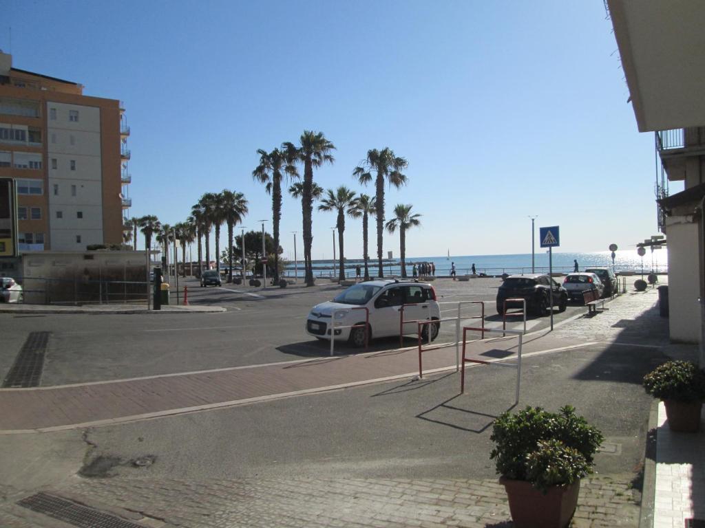 a parking lot next to the beach with palm trees at Le Casette Del Mare in Crotone