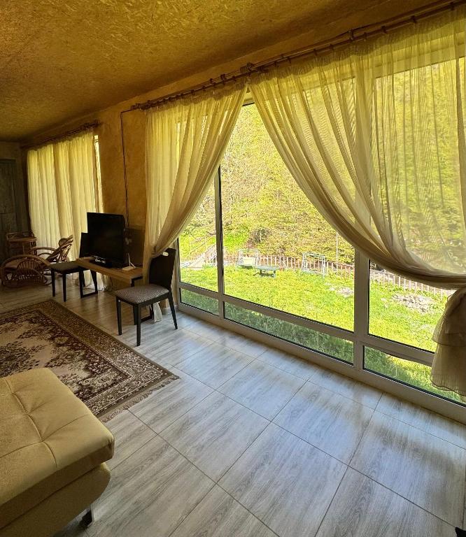 a living room with a large window and a couch at Riviera Guesthouse in Dilijan