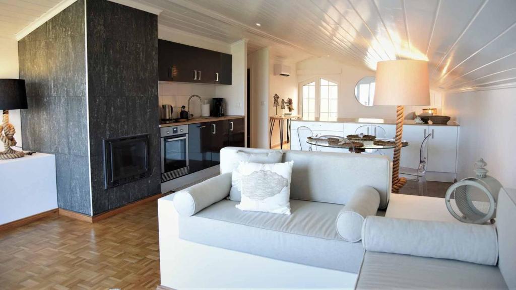 a living room with a white couch and a kitchen at JC Seaside in Vila Franca do Campo