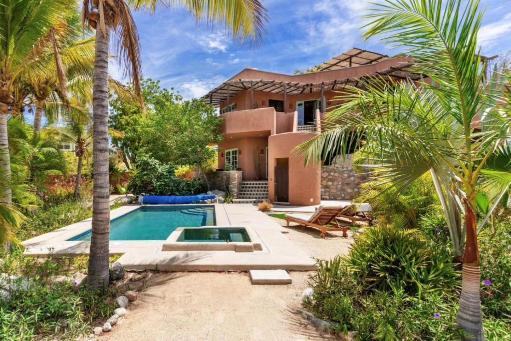 a house with a swimming pool and palm trees at Casa Silverado in Buenavista