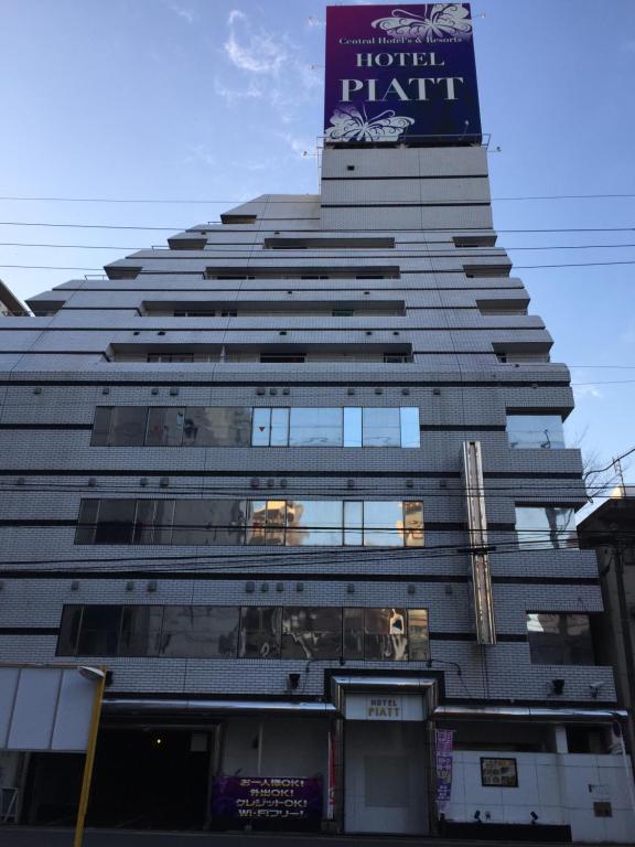 a tall building with a sign on top of it at Hotel Piatt (Adult Only) in Nagoya