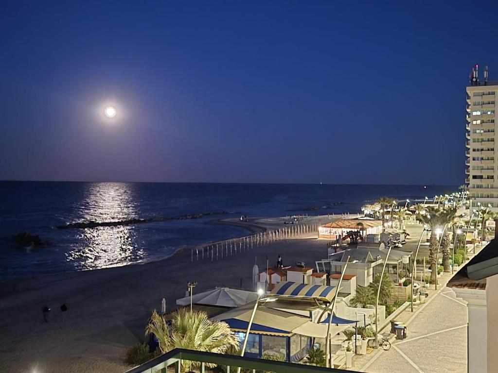 a view of a beach at night with a full moon at Affittacamere Prima Fila Mare in Porto Recanati
