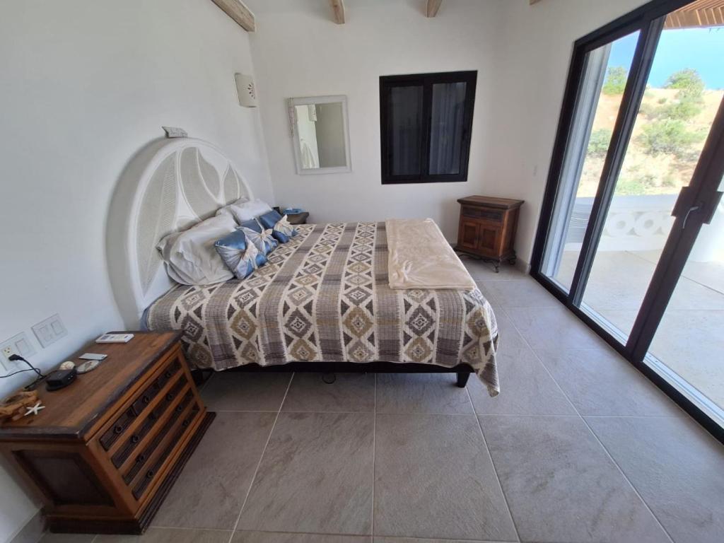 a bedroom with a bed and a table and a window at Ocean Views Pool 2 Bedroom in Los Barriles