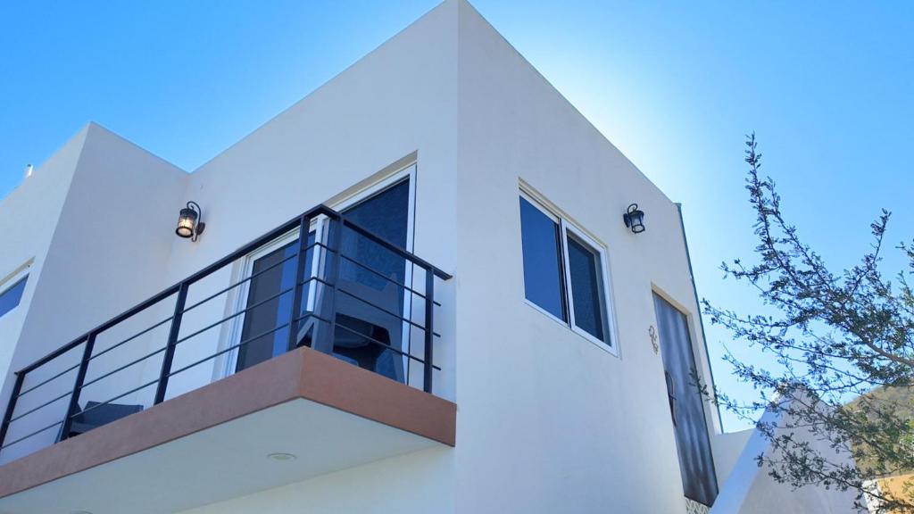 a white house with a balcony with a window at Casita GEcko in Buenavista
