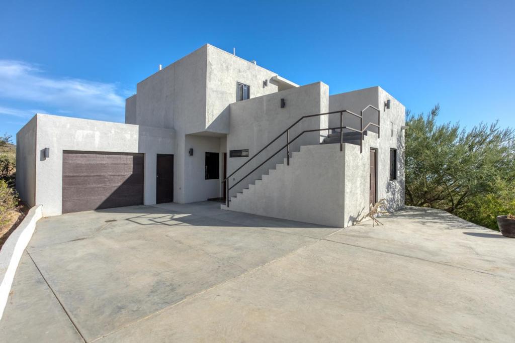 a white house with a staircase on a driveway at Pool with a View in Buena Vista in Buenavista