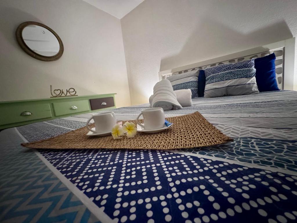 a bedroom with a bed with two cups and a rug at Sxm Caribbean Nest in Saint Martin