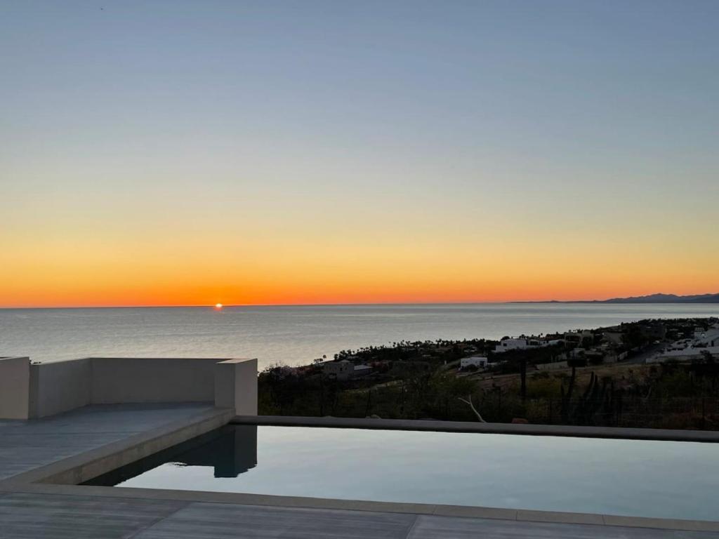a sunset over the ocean from a house with a bench at Stunning Home with Incredible Views in Los Barriles