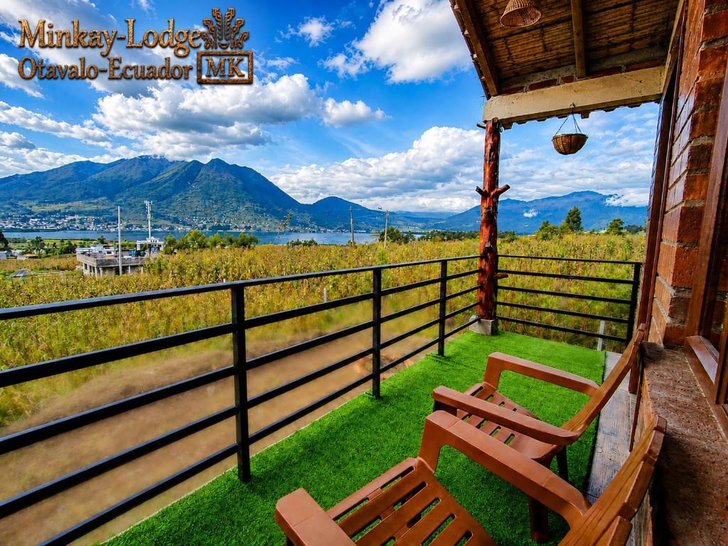 a bench on a porch with a view of the mountains at Minkay-Lodge in Otavalo