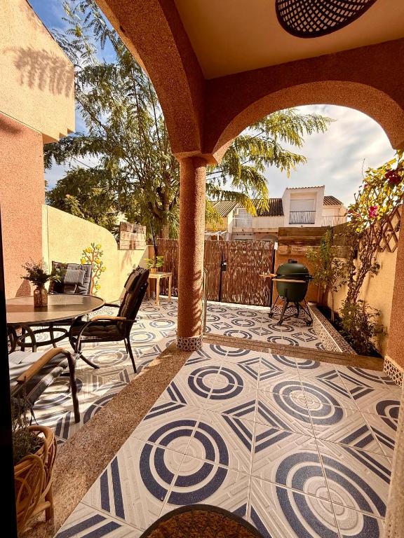 a patio with a table and chairs and a tile floor at Casa Midu Beachhouse 450m to the Beach in Los Alcázares