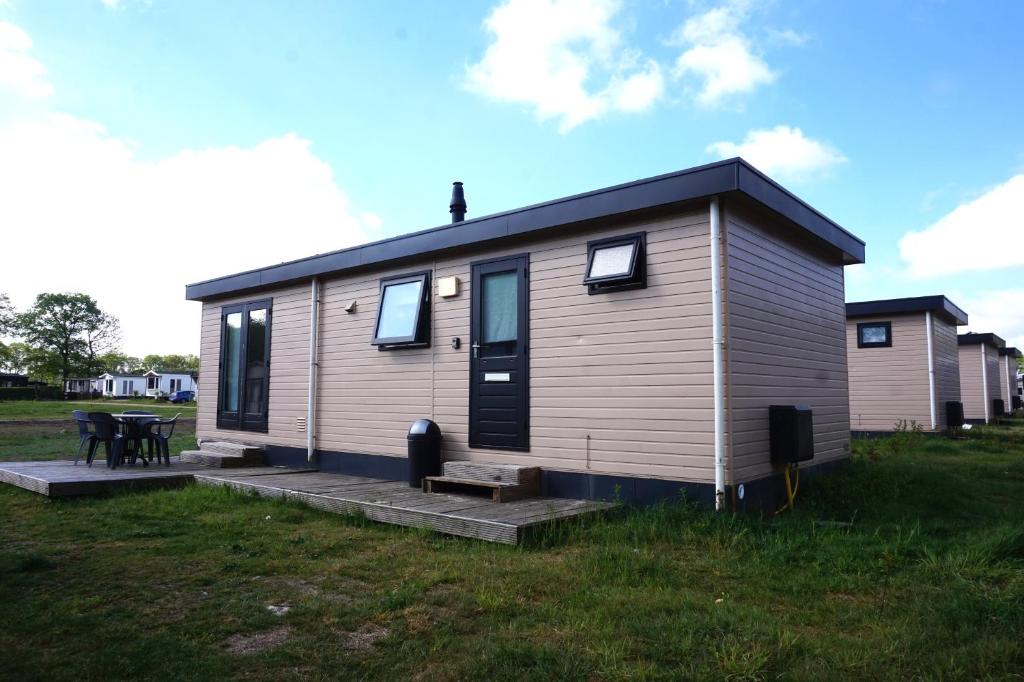 a tiny house with a picnic table in a field at 't Veldhuisje 109 - naast het bos, honden toegestaan in Anloo