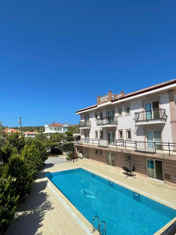a building with a swimming pool in front of a building at Maison Edina - Cunda in Ayvalık