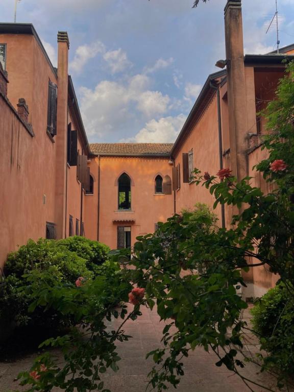 an empty courtyard of a building with a tree at Storico appartamento con parco in Sanguinetto