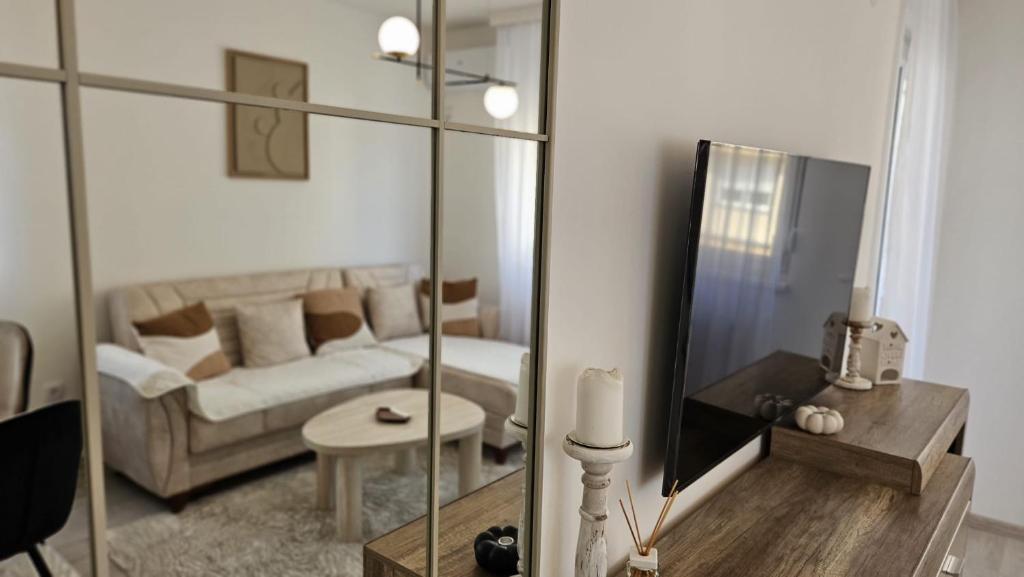 a living room with a couch and a mirror at Royal Apartman in Banja Koviljača