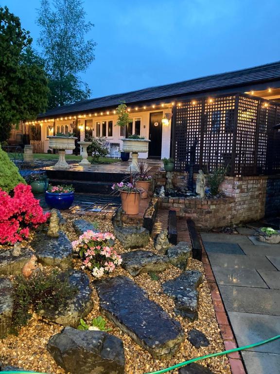 a garden with benches and flowers in front of a building at Primrose Cottage Westhead in Westhead