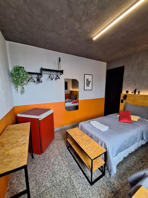 a bedroom with a bed and a table in a room at MEC Office Hostel in Niterói
