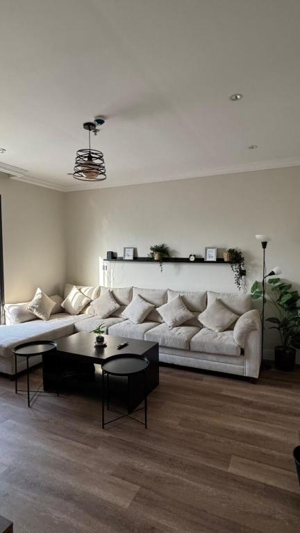 a living room with a white couch and a table at نسمة الخبر كورنيش اقامة رائعة وهادئة in Dammam