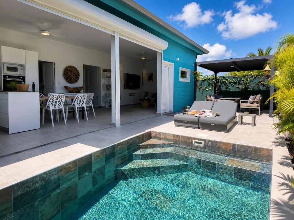 a swimming pool in the middle of a yard with a house at Villa Docéa in Sainte-Anne