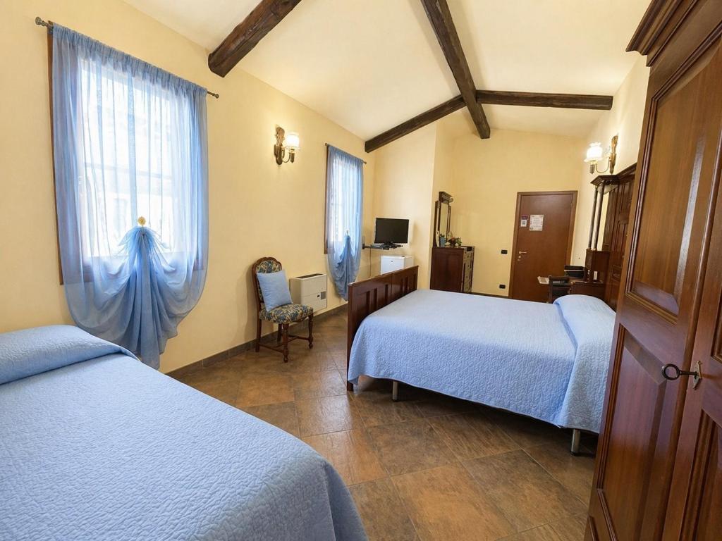 a hotel room with two beds and a window at B&B Il Fiocinino in Comacchio