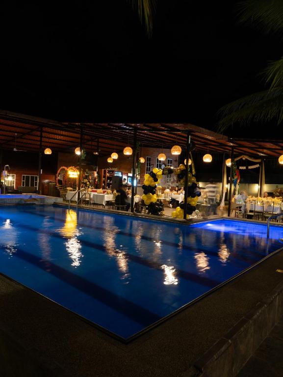 a swimming pool at night with lights on at Salamandras Hostería & Spa in Tena