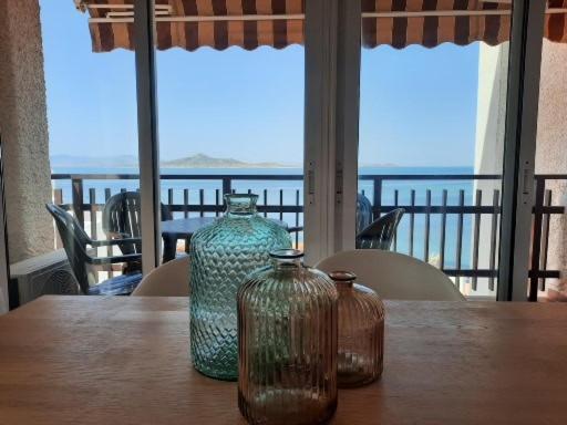 two glass vases sitting on a wooden table with a view at Casa Gaia in La Manga del Mar Menor