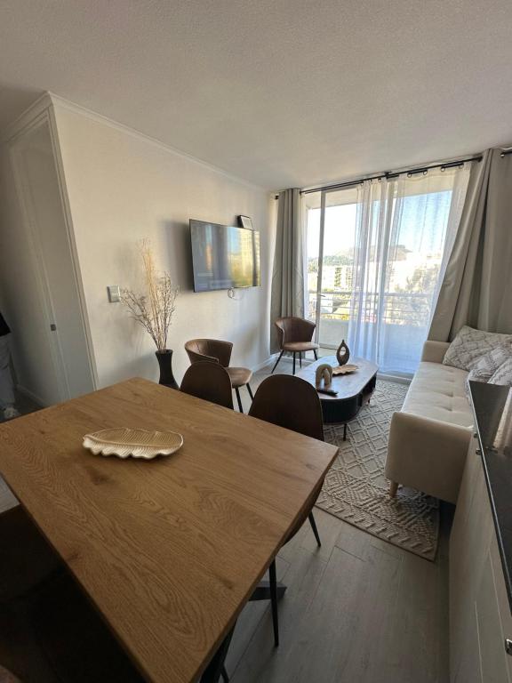 a living room with a table and a living room with a couch at Moderno Departamento Viña del Mar in Viña del Mar