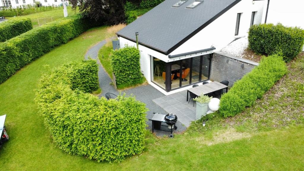 eine Luftaufnahme eines weißen Hauses mit Terrasse in der Unterkunft Sakura Lodging in Bossut-Gottechain