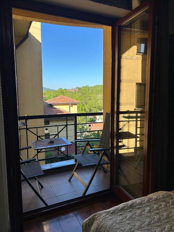 a room with a balcony with a bed and a view at Apartman Temida Lux in Vrnjačka Banja
