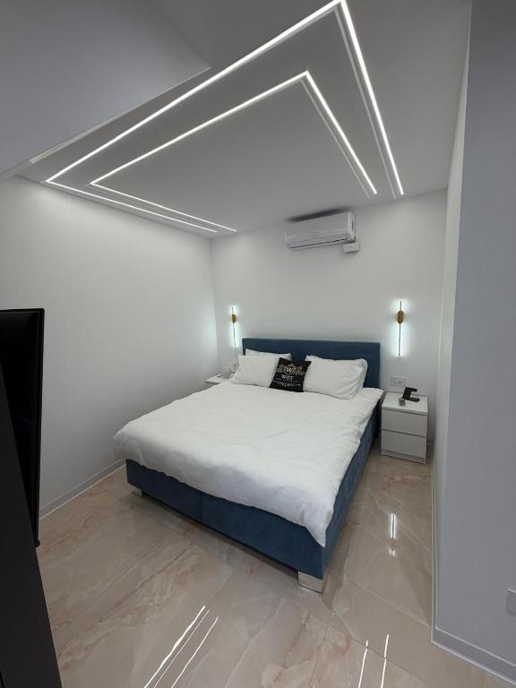 a bedroom with a large bed and a white ceiling at WOT Rose Residence in Arad