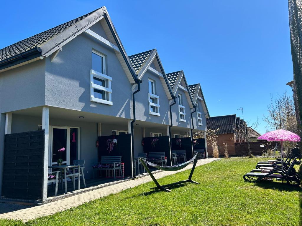 a house with a hammock in the yard at Poprzeczna 7 in Sarbinowo
