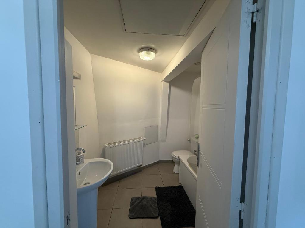 a white bathroom with a sink and a toilet at Appartement in Roubaix