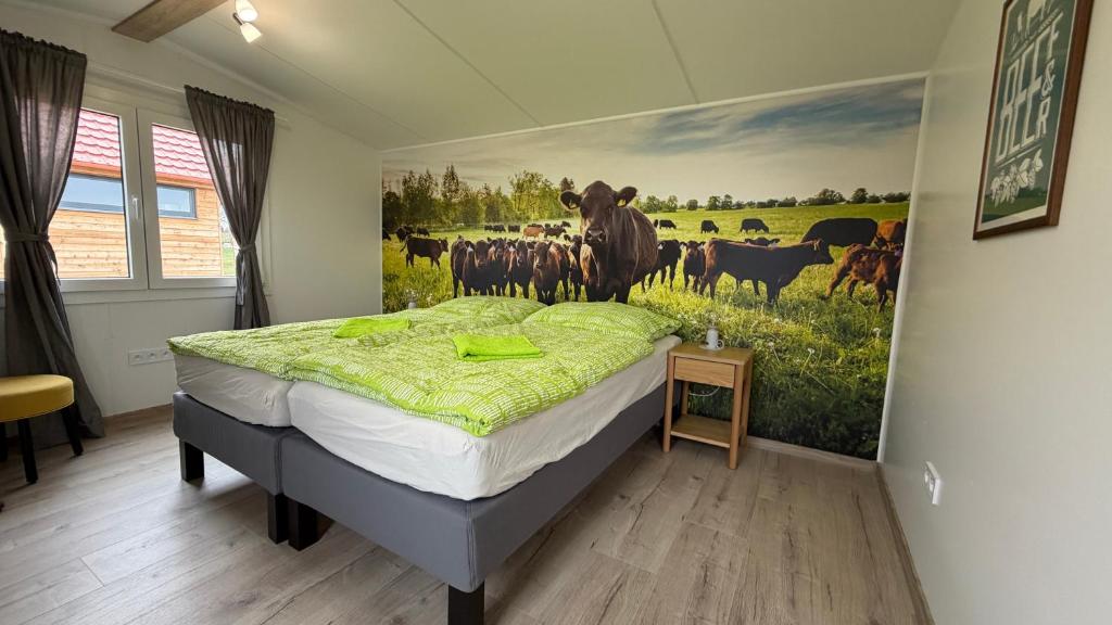 a bedroom with a painting of cows in a field at Camping Mitrov in Strážek