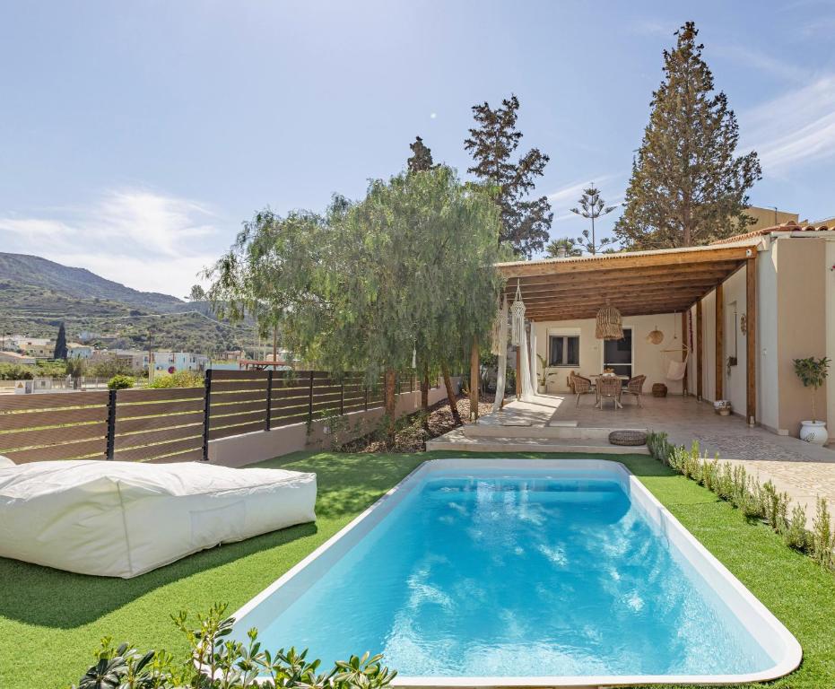 a swimming pool in the yard of a house with a backyard at Seaside Breeze Villa - Beachfront, Private Pool, BBQ in Agia Pelagia