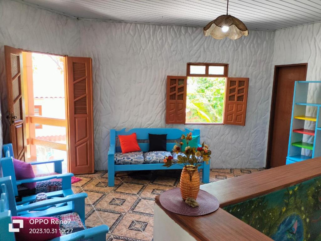 a living room with blue chairs and a couch at Pousada pôr do sol in Cairu