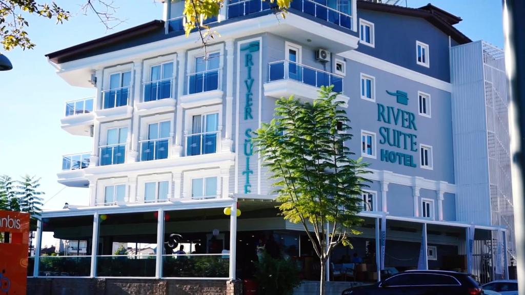 a large white building with a sign on it at River suite hotel in Manavgat